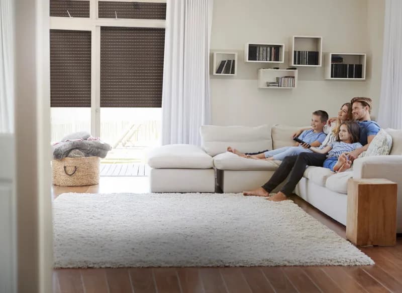 Family in a living room with half-closed roller shutters