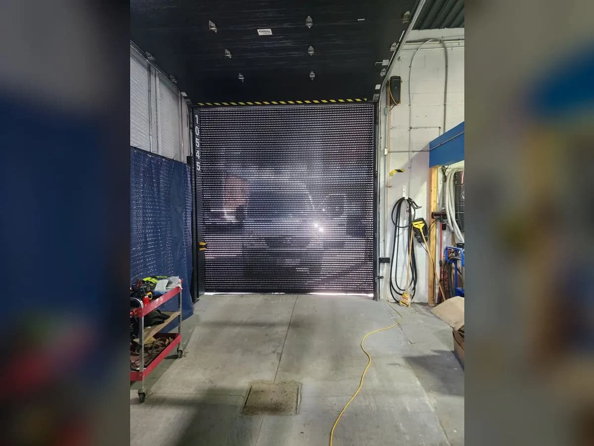 Perforated roll-up door in a workshop
