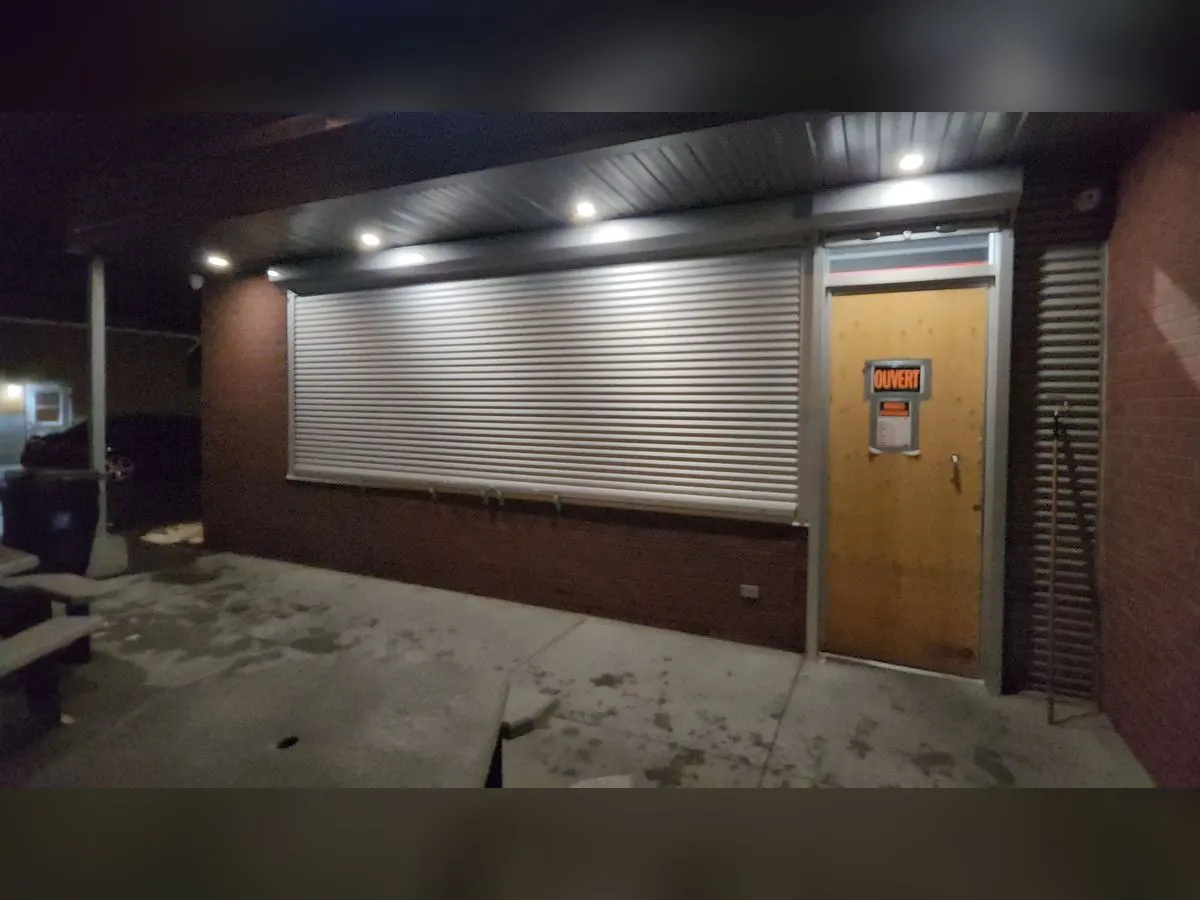 Storefront closed at night by a large shutter