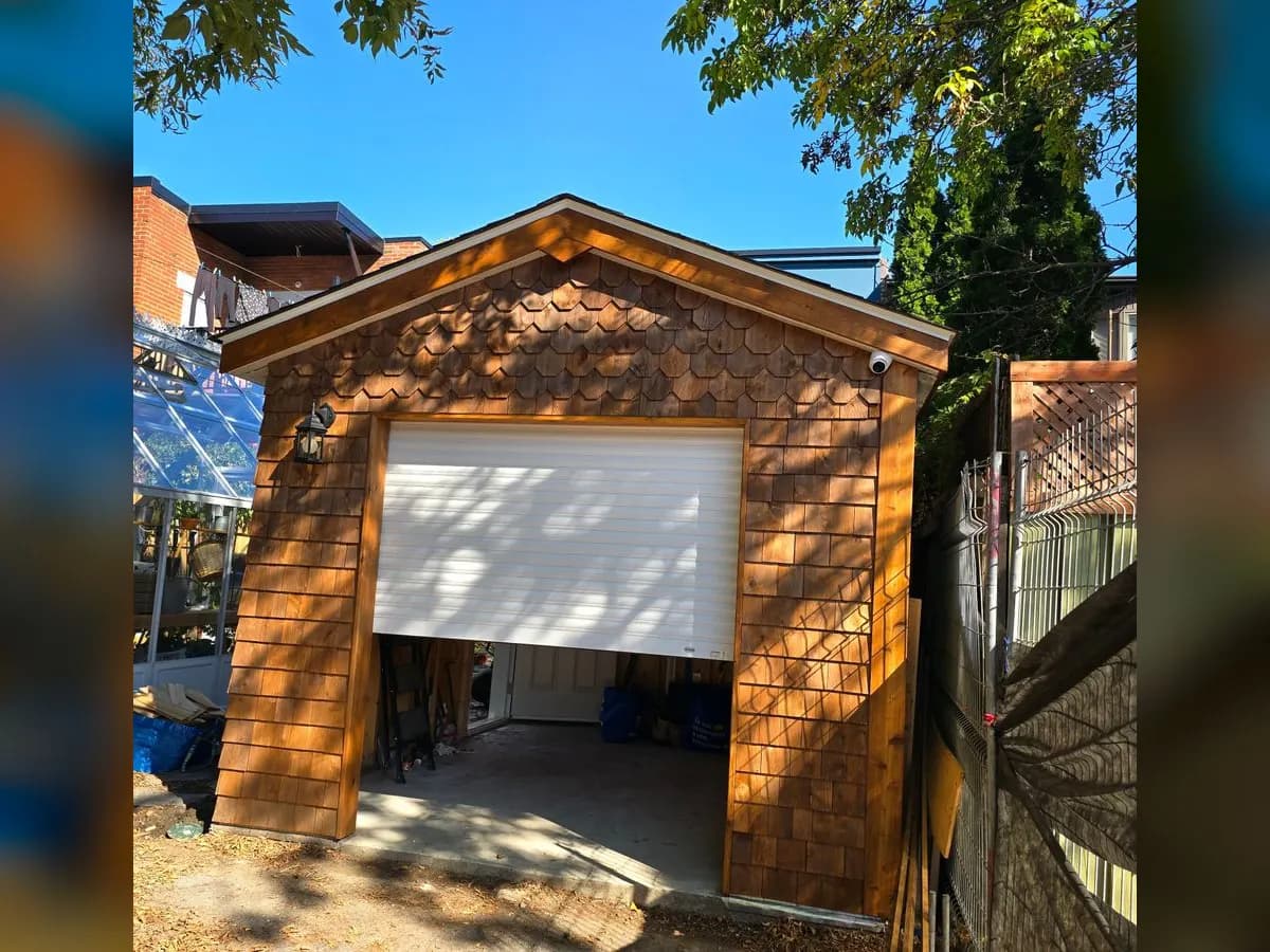 Shingled garage with a white roll-up door