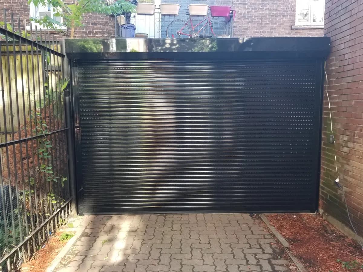Black roll-up door closing off a yard