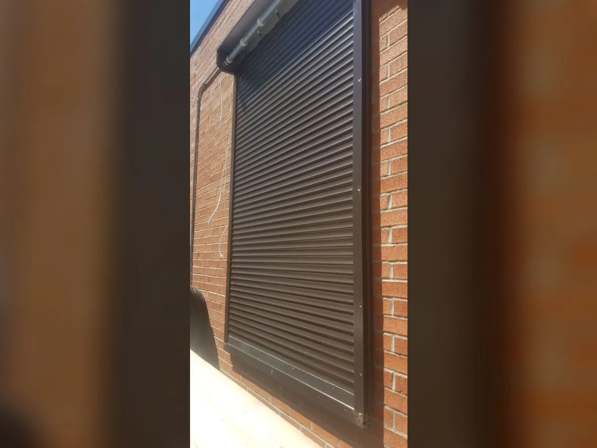 Black shutter on a brick wall